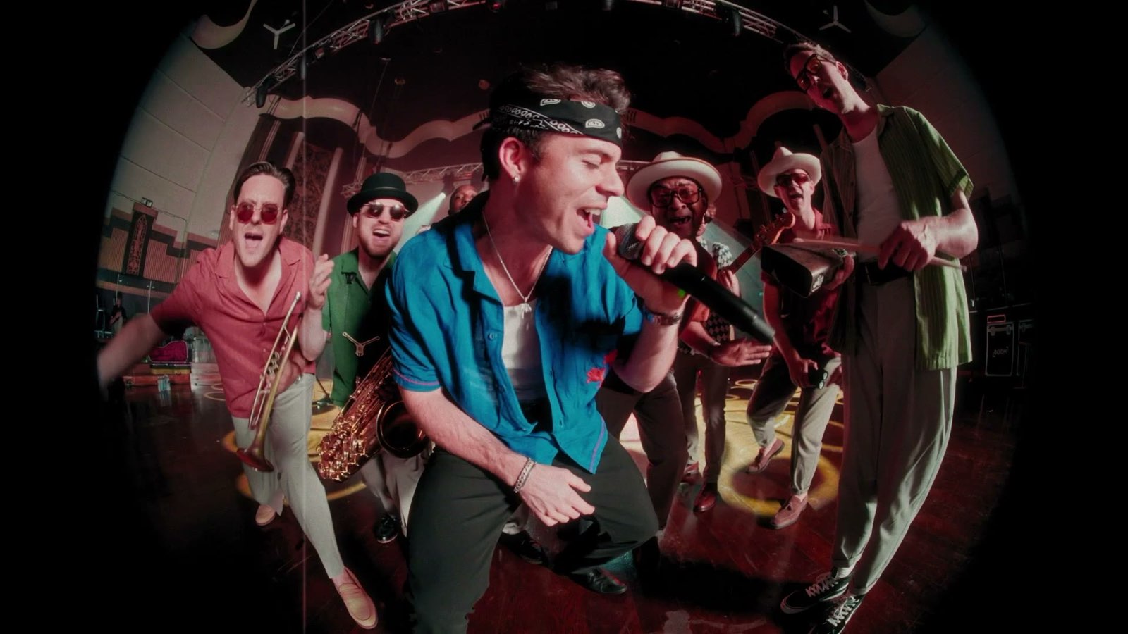 Casa performing on stage, the singer in a blue shirt leading the band